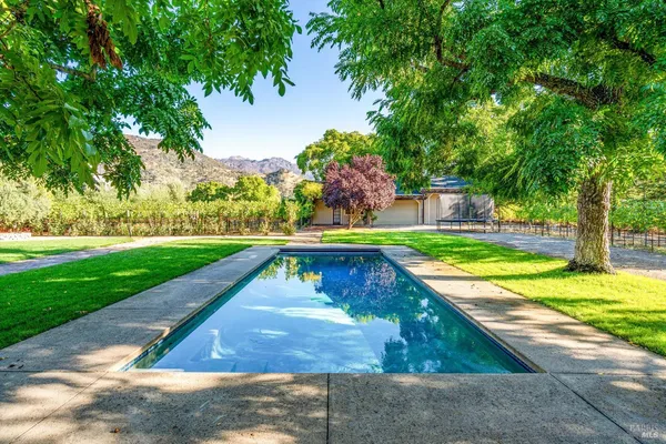 a view of a house with a yard and basketball court