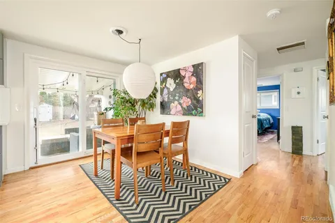 a view of a dining room with furniture a chandelier and wooden floor