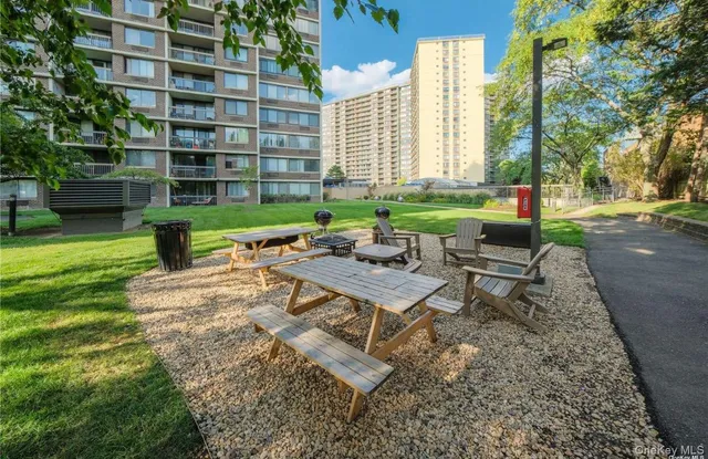 a view of a patio with table and chairs potted plants and a large tree