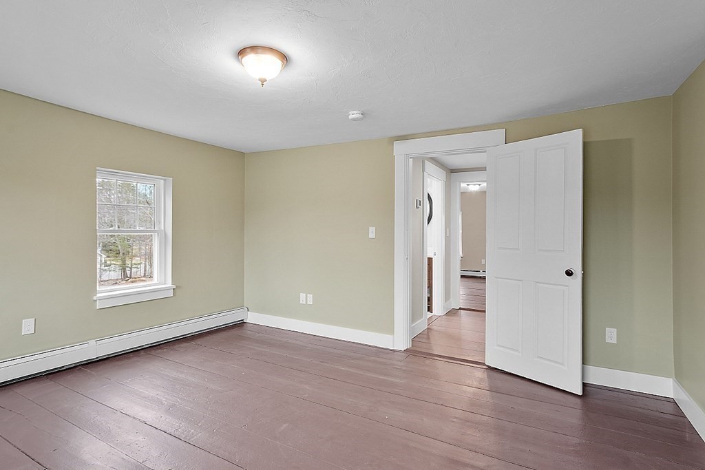 335 Chase Road Lunenburg, MA 01462 - Photo 35 of 42 a view of an empty room with a window and wooden floor