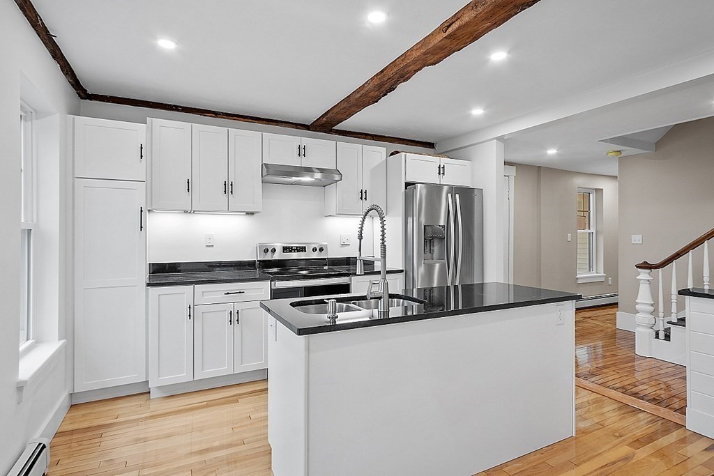 335 Chase Road Lunenburg, MA 01462 - Photo 10 of 42 a kitchen with stainless steel appliances granite countertop a stove a refrigerator a sink and white cabinets