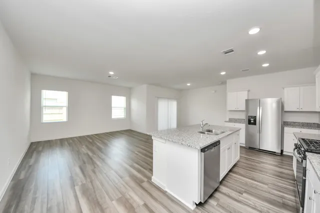 a large kitchen with stainless steel appliances granite countertop a stove and a sink