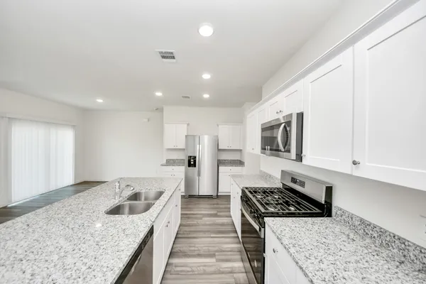 a kitchen with a stove a sink and a refrigerator