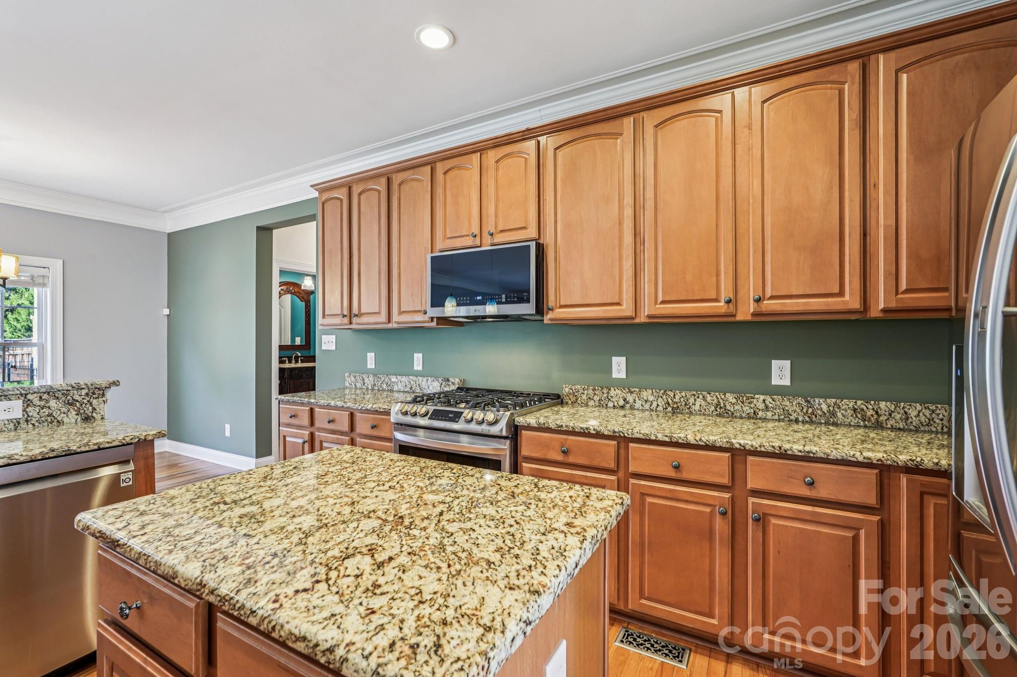 8348 Rocky River Road Harrisburg, NC 28075 - Photo 12 of 47 a kitchen with stainless steel appliances granite countertop wooden cabinets and a counter top space