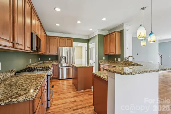 a kitchen with stainless steel appliances granite countertop a sink stove and refrigerator