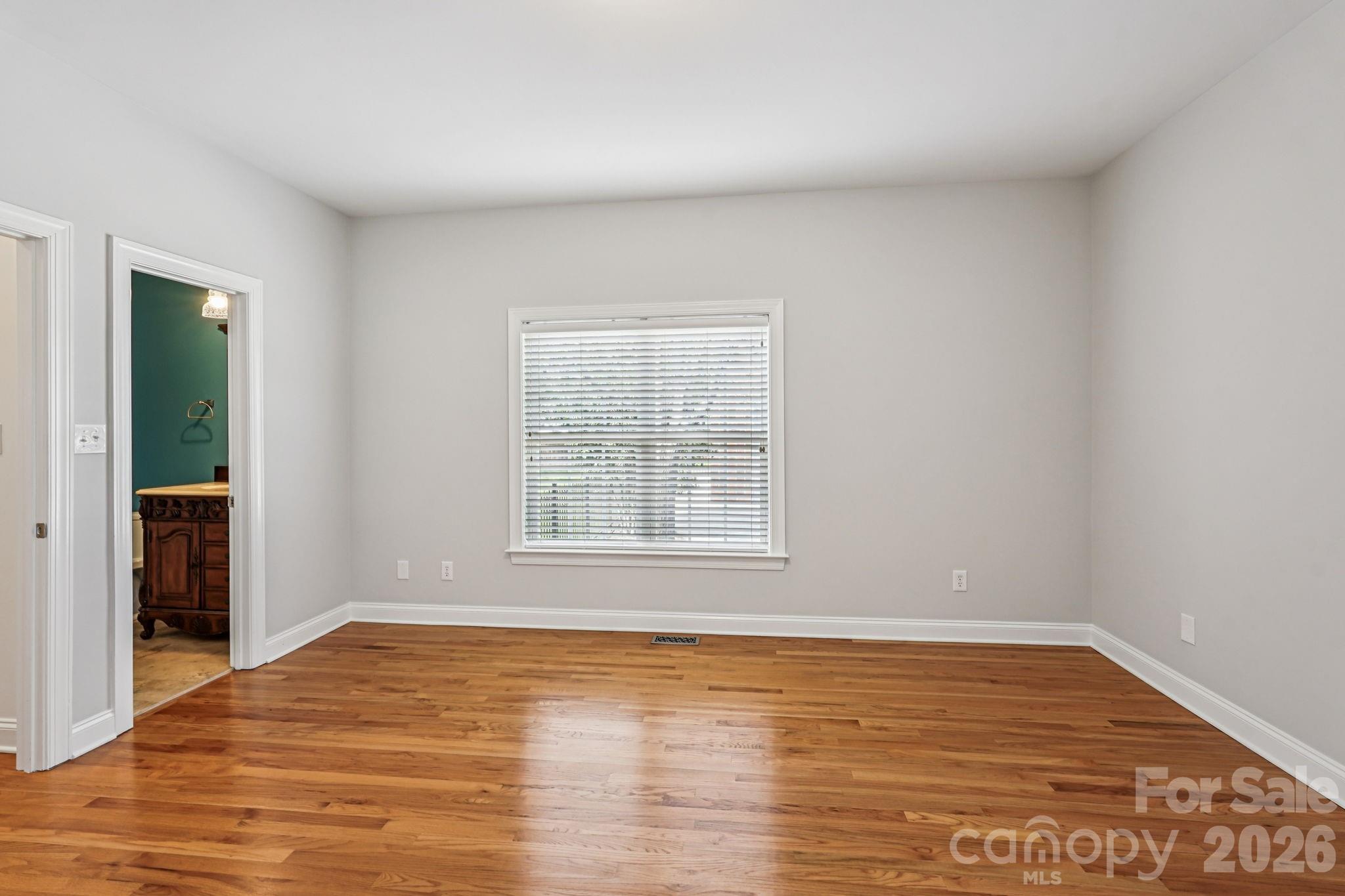 8348 Rocky River Road Harrisburg, NC 28075 - Photo 17 of 47 an empty room with wooden floor and windows