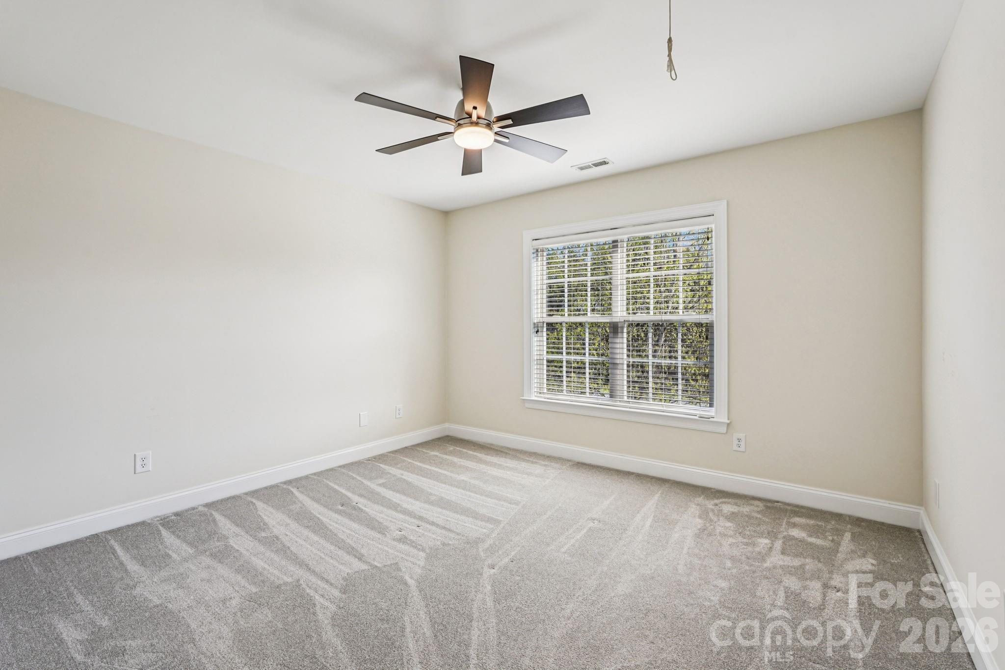 8348 Rocky River Road Harrisburg, NC 28075 - Photo 21 of 47 an empty room with window and ceiling fan