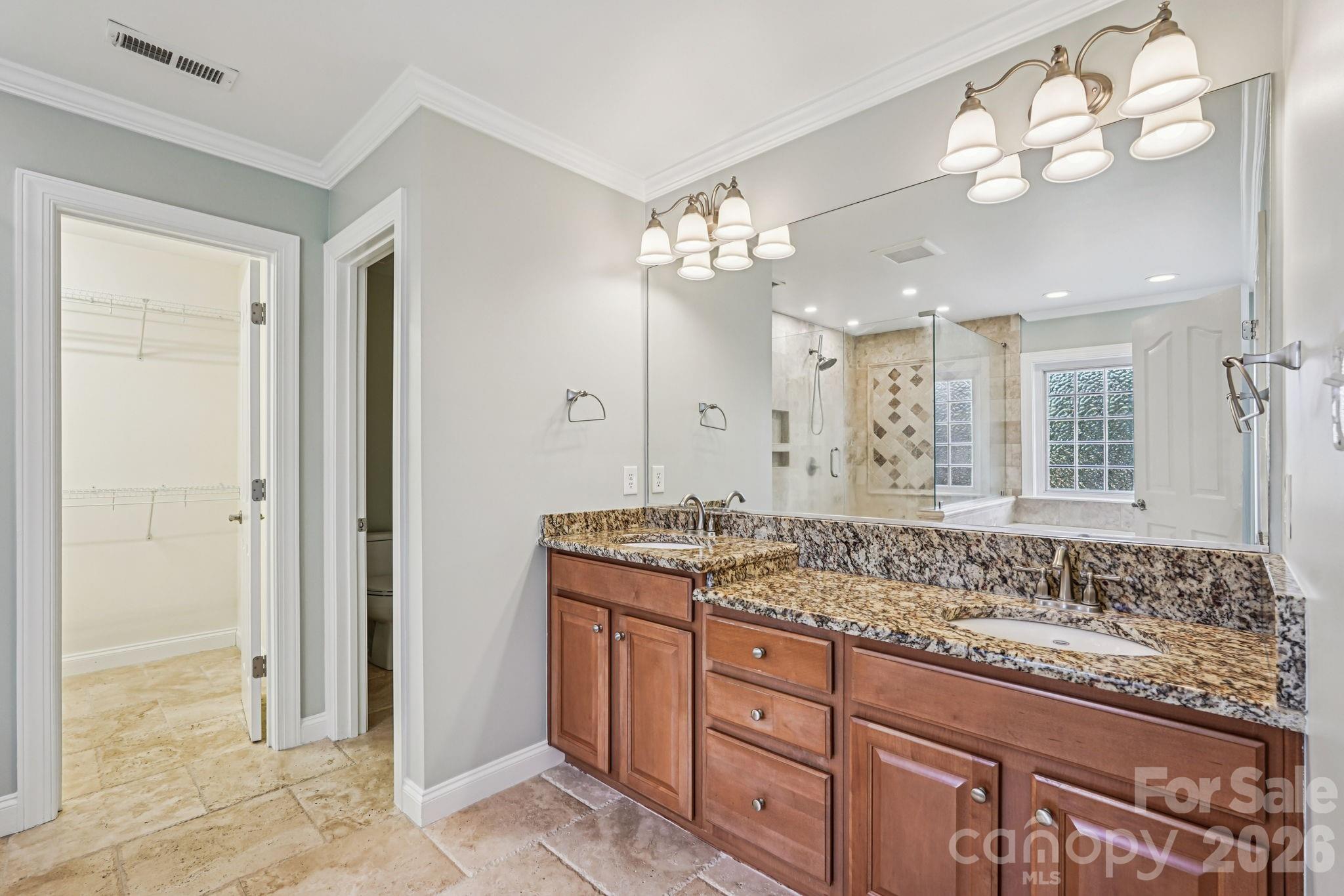 8348 Rocky River Road Harrisburg, NC 28075 - Photo 25 of 47 a bathroom with a granite countertop sink a large mirror and a shower