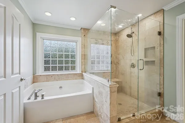 a bathroom with a bathtub a shower a sink and a mirror