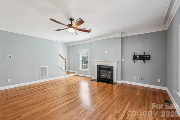 a view of empty room with wooden floor and fireplace