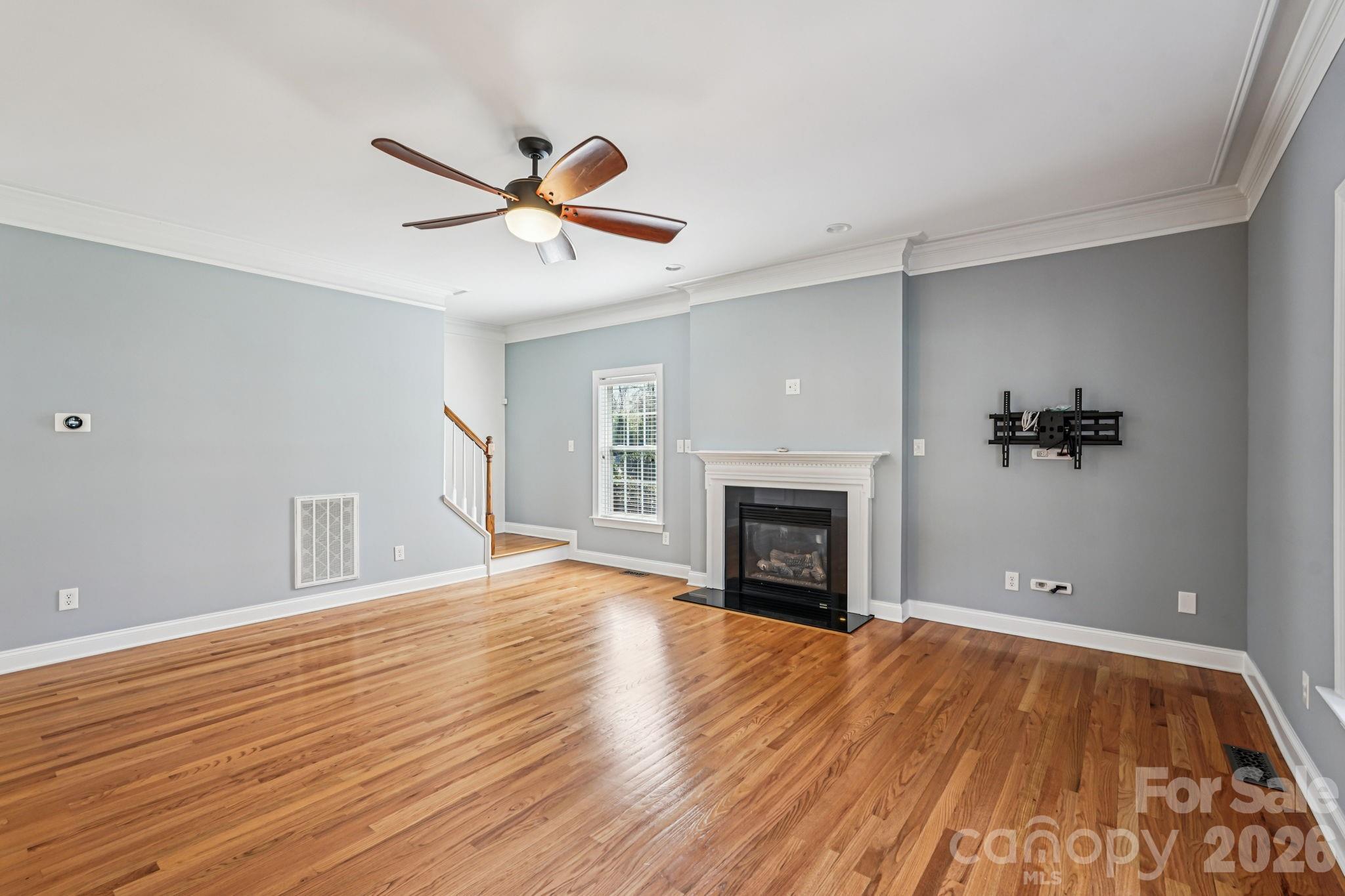 8348 Rocky River Road Harrisburg, NC 28075 - Photo 7 of 47 a view of empty room with wooden floor and fireplace