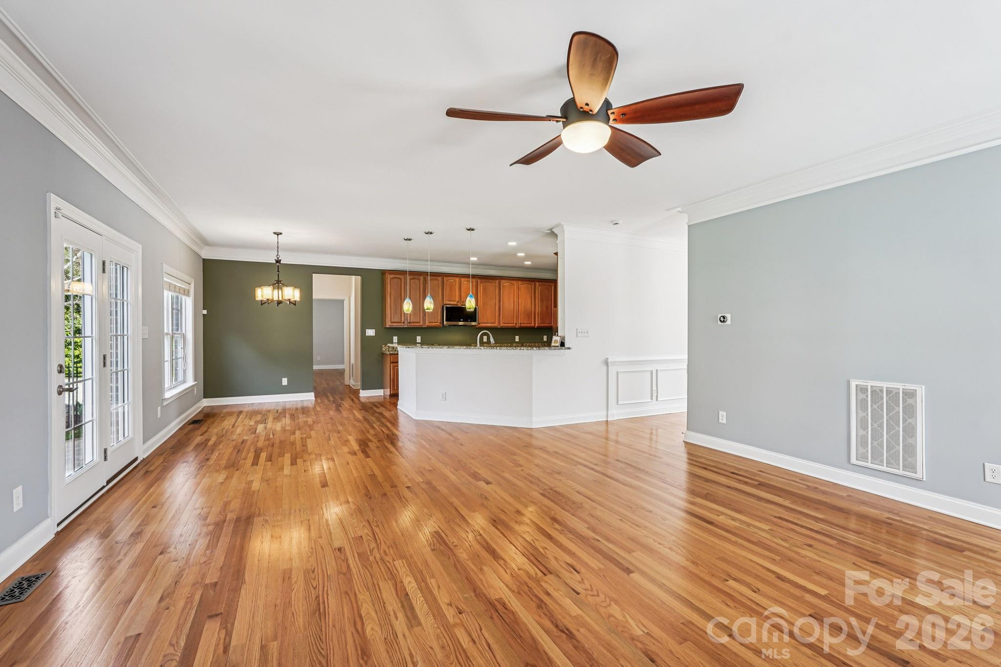 8348 Rocky River Road Harrisburg, NC 28075 - Photo 8 of 47 a view of a livingroom with a ceiling fan and wooden floor