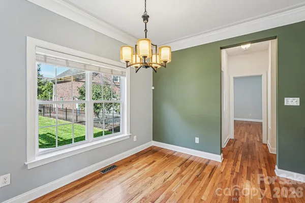 a view of a room with wooden floor fan and windows