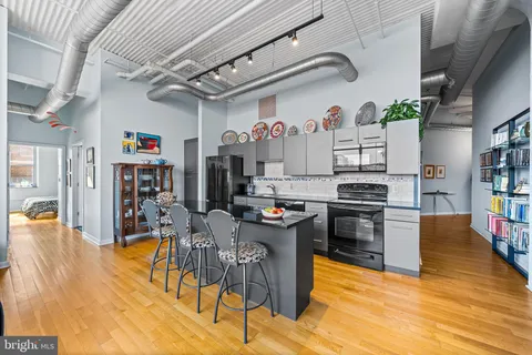 a living room with lots of furniture and center kitchen