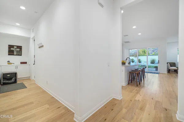 a kitchen with stainless steel appliances granite countertop a stove a sink a refrigerator a dining table and chairs with wooden floor