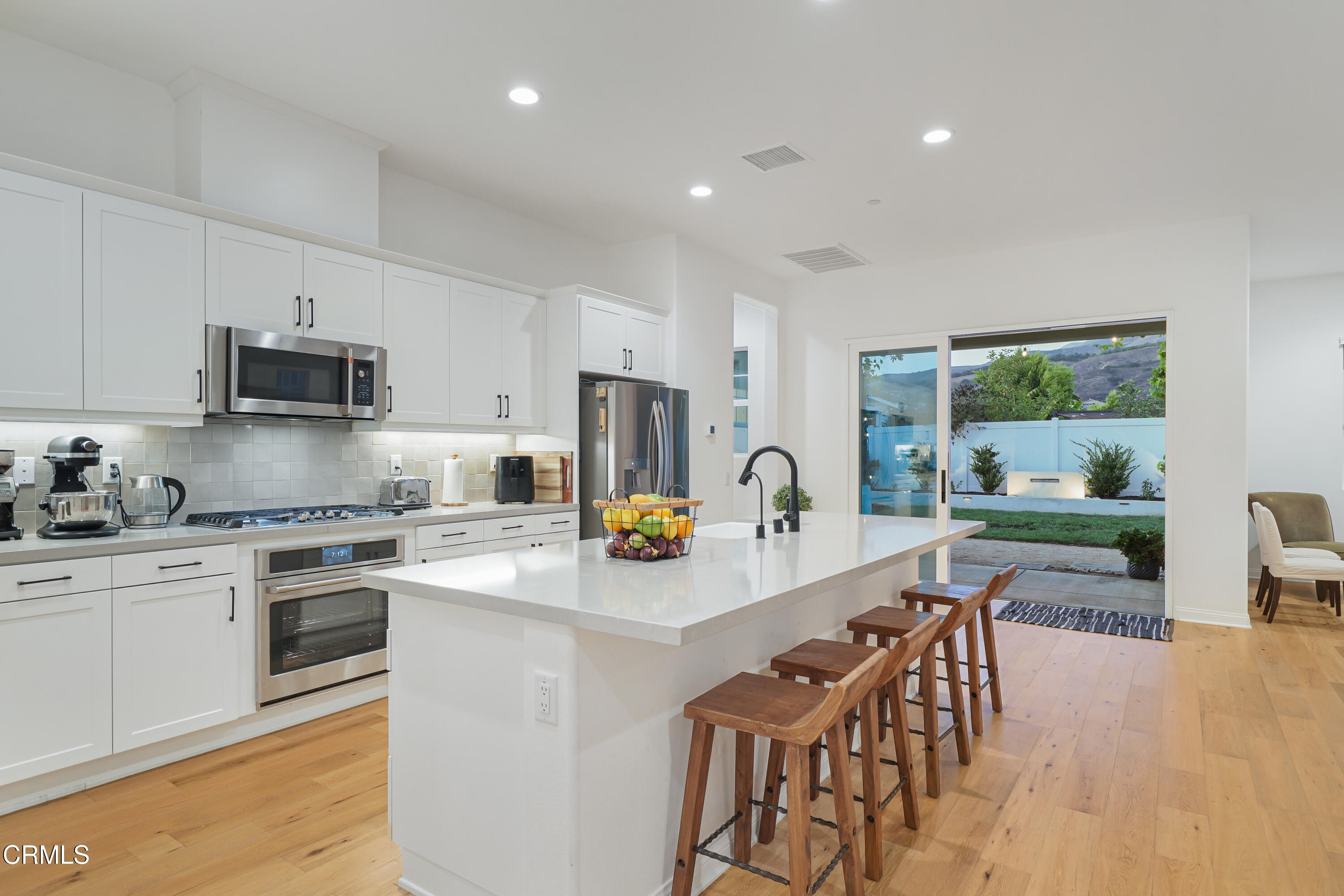 263 Wisteria Street Fillmore, CA 93015 - Photo 26 of 51 a kitchen with stainless steel appliances granite countertop a stove a sink a refrigerator a dining table and chairs with wooden floor