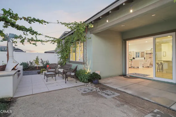 a view of a patio with couches table and chairs and potted plants