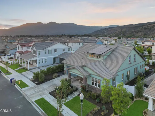 a aerial view of a house with a yard and large tree