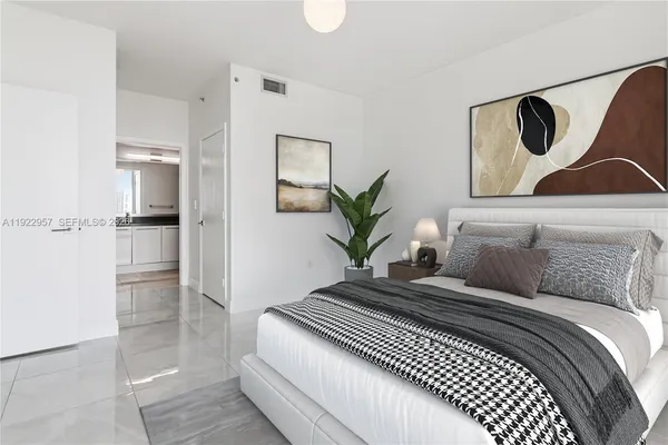 a bedroom with a large bed and potted plant