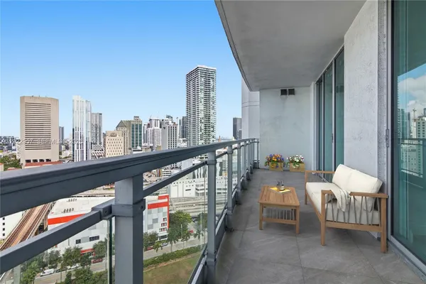 a balcony with furniture and a view of living room