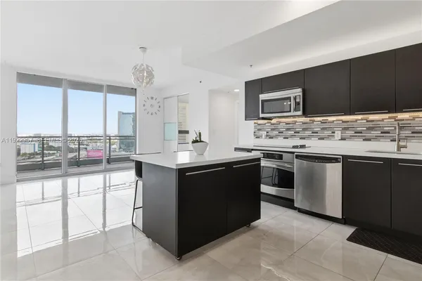 a kitchen with stainless steel appliances kitchen island granite countertop a sink and cabinets