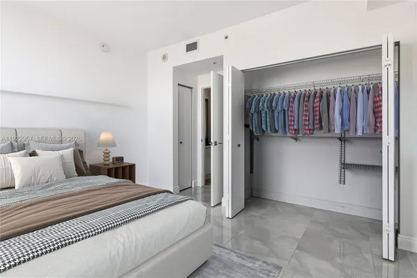 a bedroom with a bed and a refrigerator