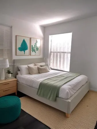 a bedroom with a bed mirror and window