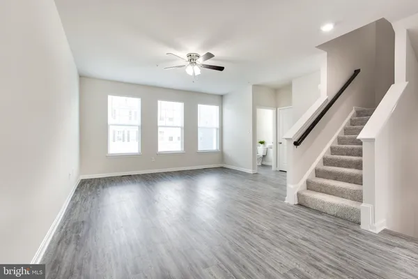 a view of a livingroom with wooden floor and a large window