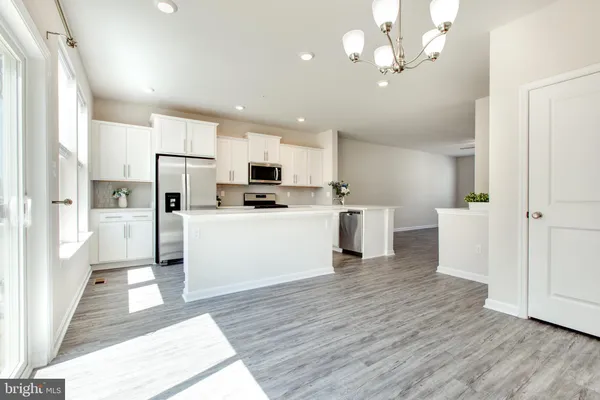 a kitchen with stainless steel appliances granite countertop a sink a stove a refrigerator a microwave and cabinets