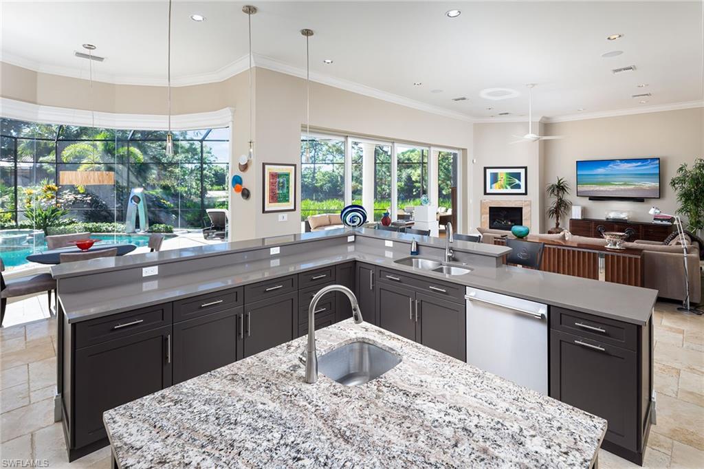 11617 Useppa Court Naples, FL 34110 - Photo 13 of 50 a kitchen with stainless steel appliances granite countertop a sink stove and refrigerator