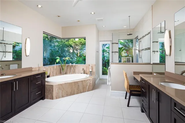 a bathroom with a tub sink and mirror