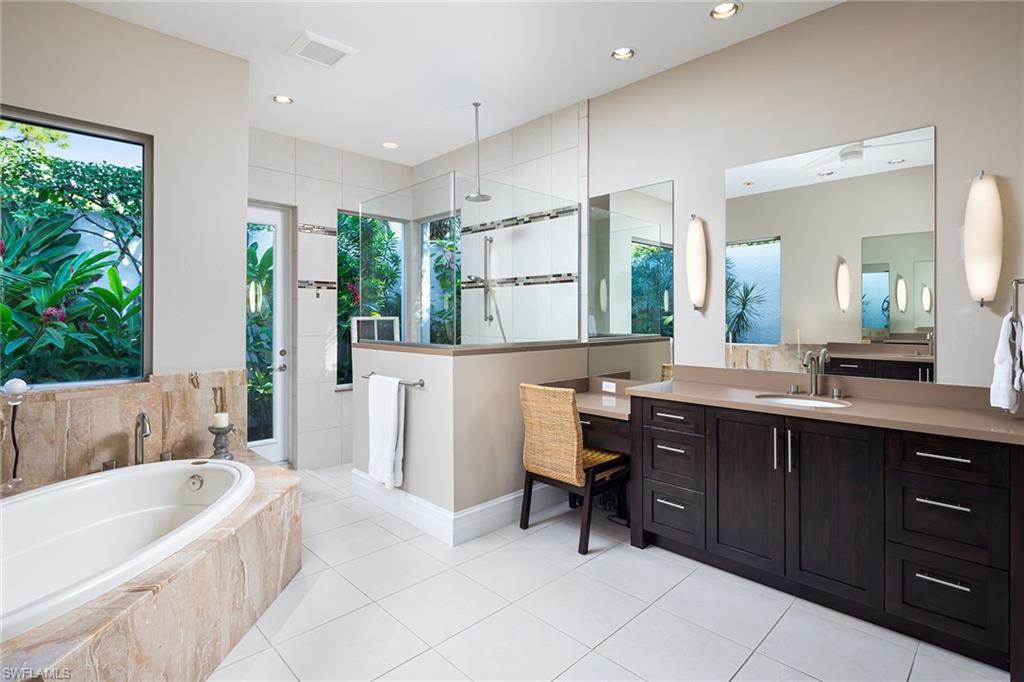 11617 Useppa Court Naples, FL 34110 - Photo 20 of 50 a bathroom with a tub sink and mirror