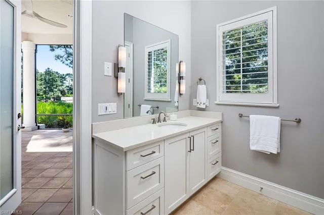 a bathroom with a granite countertop sink a toilet and a large mirror