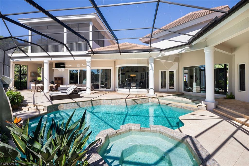 11617 Useppa Court Naples, FL 34110 - Photo 35 of 50 a view of a patio with table and chairs under an umbrella