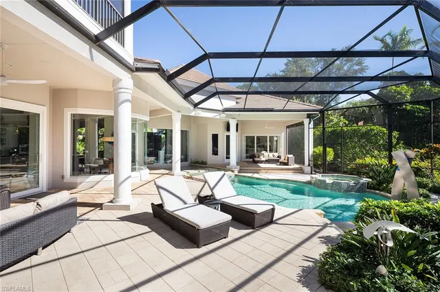 a living room with patio furniture and a potted plant