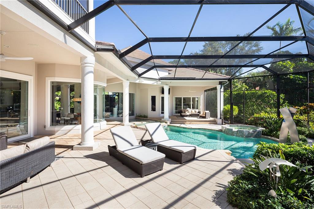 11617 Useppa Court Naples, FL 34110 - Photo 37 of 50 a view of a patio with couches table and chairs under an umbrella
