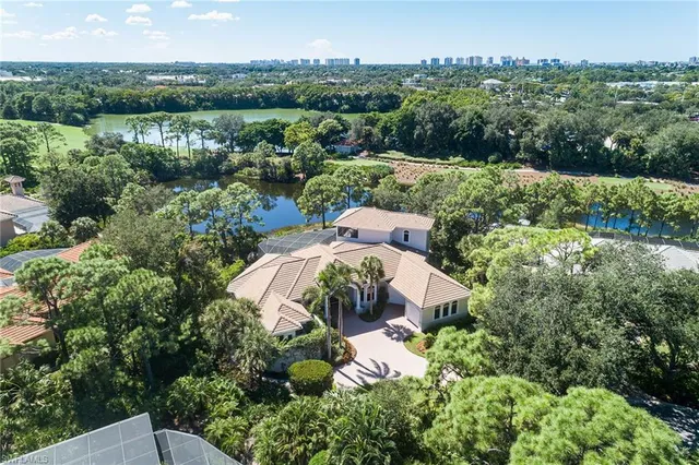 an aerial view of residential house with outdoor space and trees all around