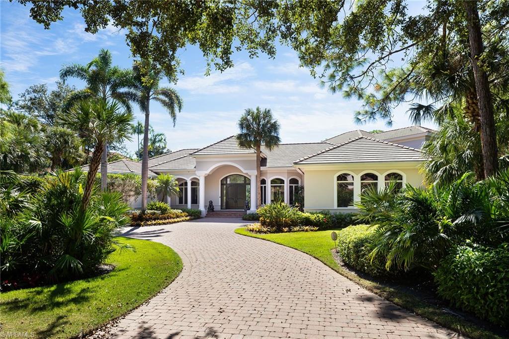 11617 Useppa Court Naples, FL 34110 - Photo 47 of 50 a front view of a house with a yard and potted plants