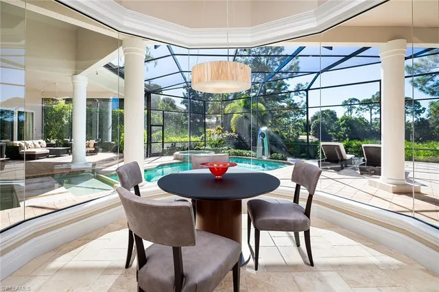 a dining room with furniture and a floor to ceiling window
