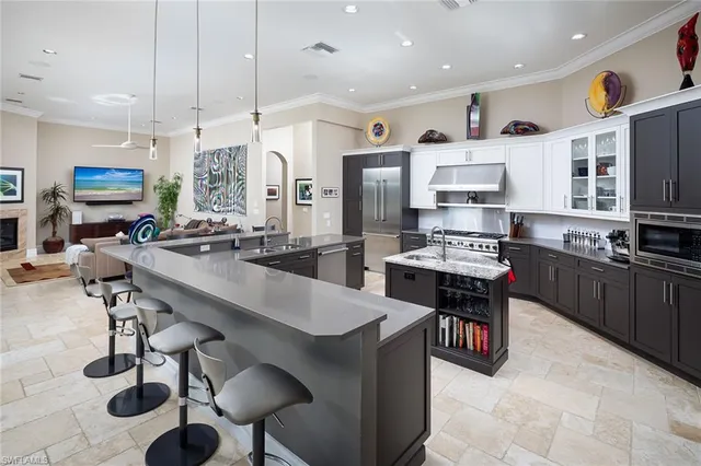 a kitchen with stainless steel appliances kitchen island granite countertop a sink a stove and a refrigerator
