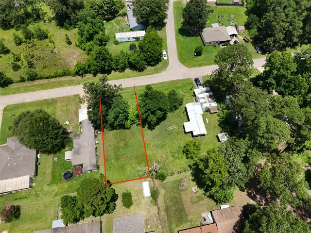 an aerial view of residential house with outdoor space and trees all around