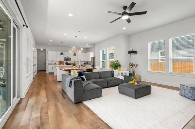 a living room with furniture kitchen and a large window
