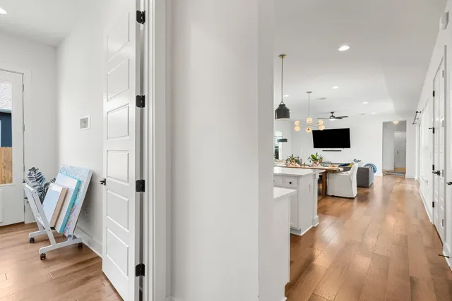 a view of a kitchen with refrigerator and wooden floor
