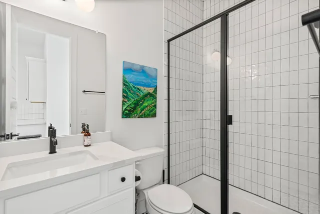 a bathroom with a sink a toilet and shower