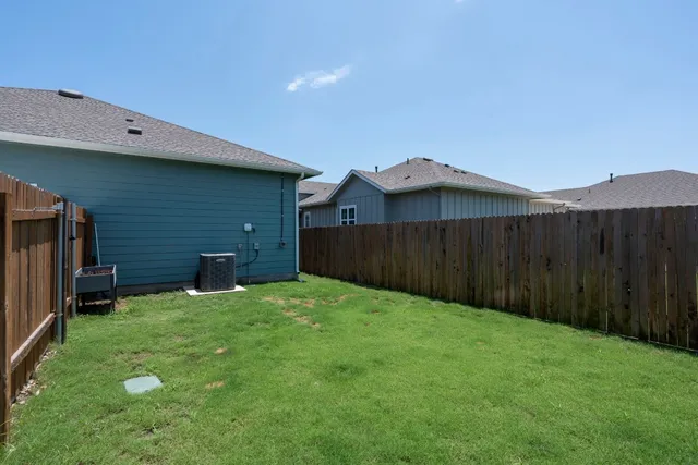 a view of a backyard with wooden fence