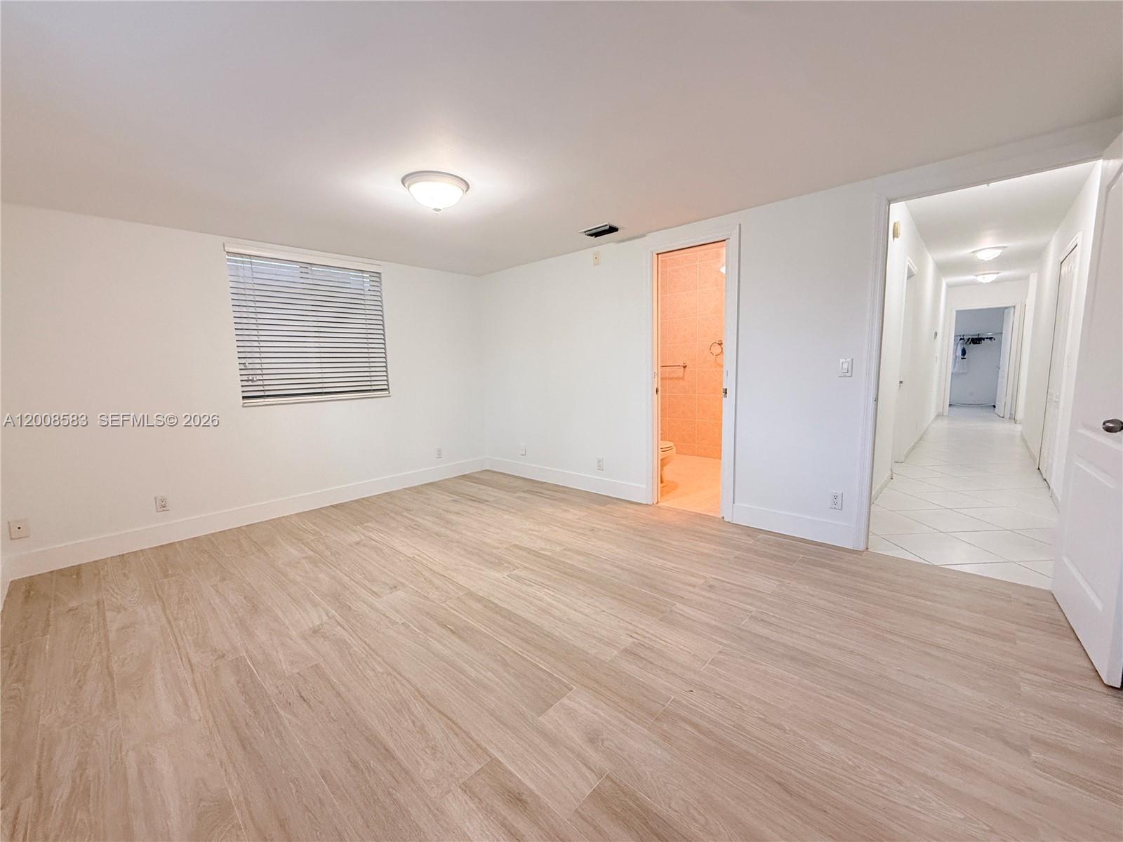 13431 Southwest 32nd Street Miami, FL 33165 - Photo 31 of 77 an empty room with wooden floor and windows
