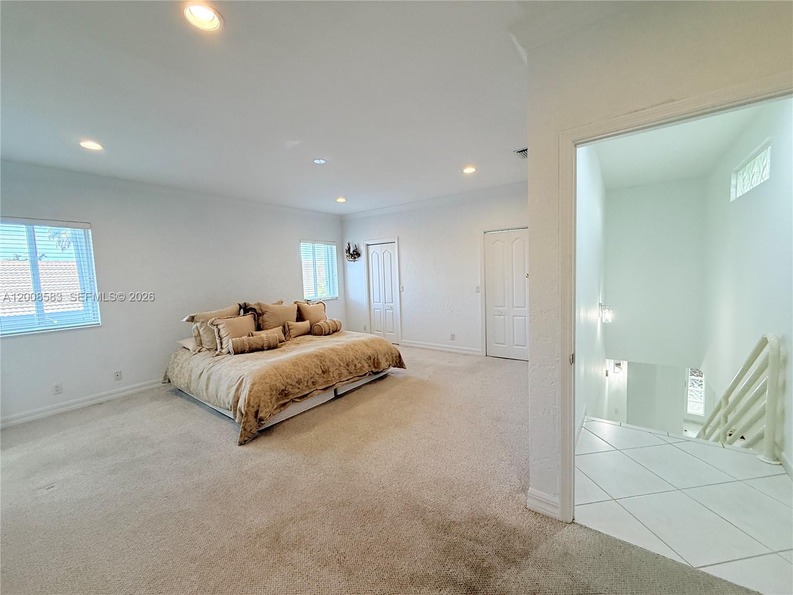 13431 Southwest 32nd Street Miami, FL 33165 - Photo 47 of 77 a spacious bedroom with a bed and a night stand
