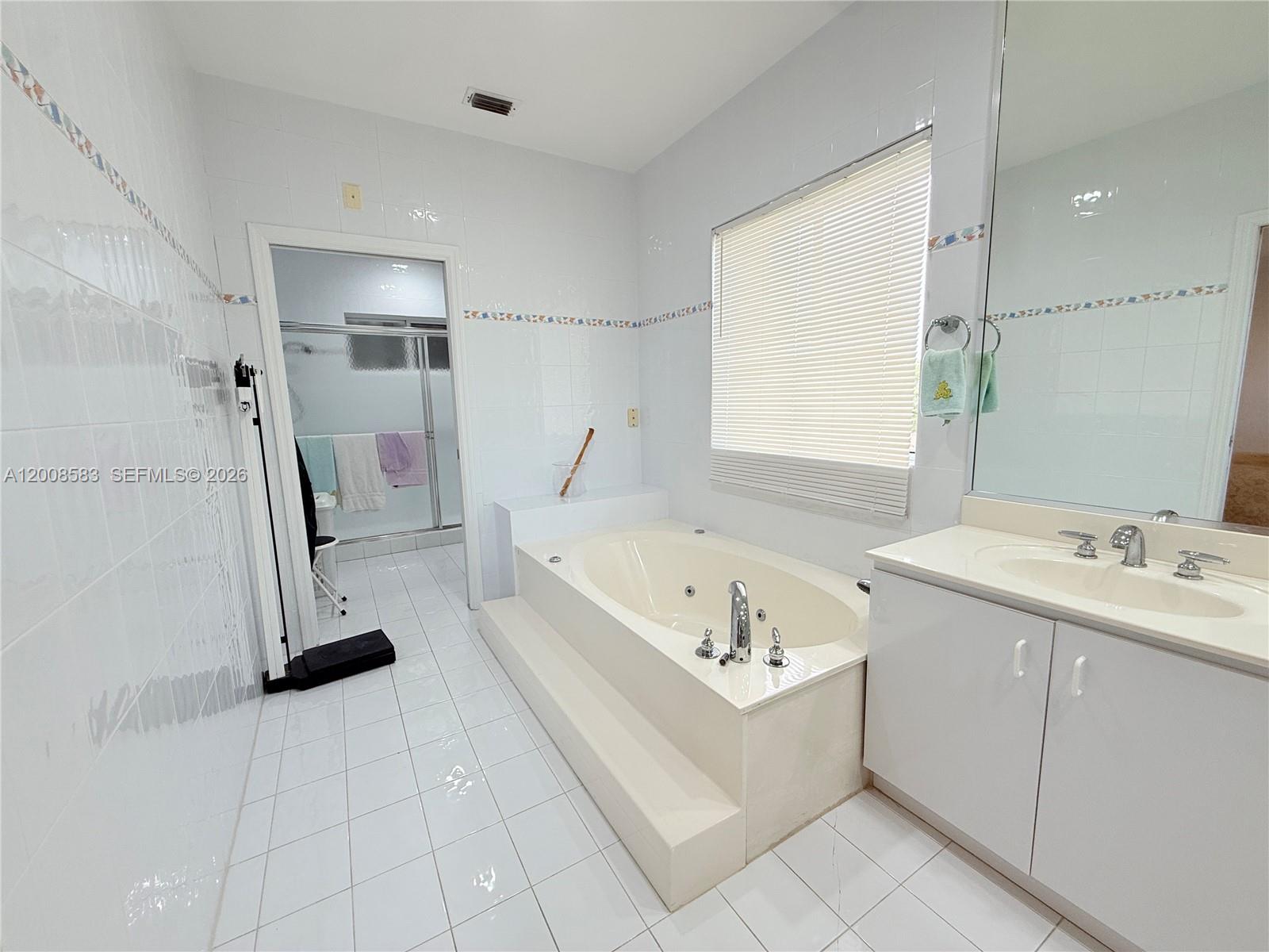 13431 Southwest 32nd Street Miami, FL 33165 - Photo 52 of 77 a bathroom with a sink a bathtub and a shower