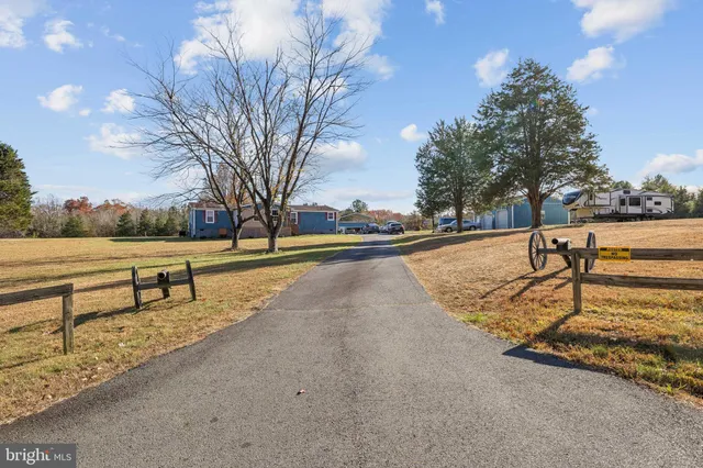 a view of street with yard and trees in the background