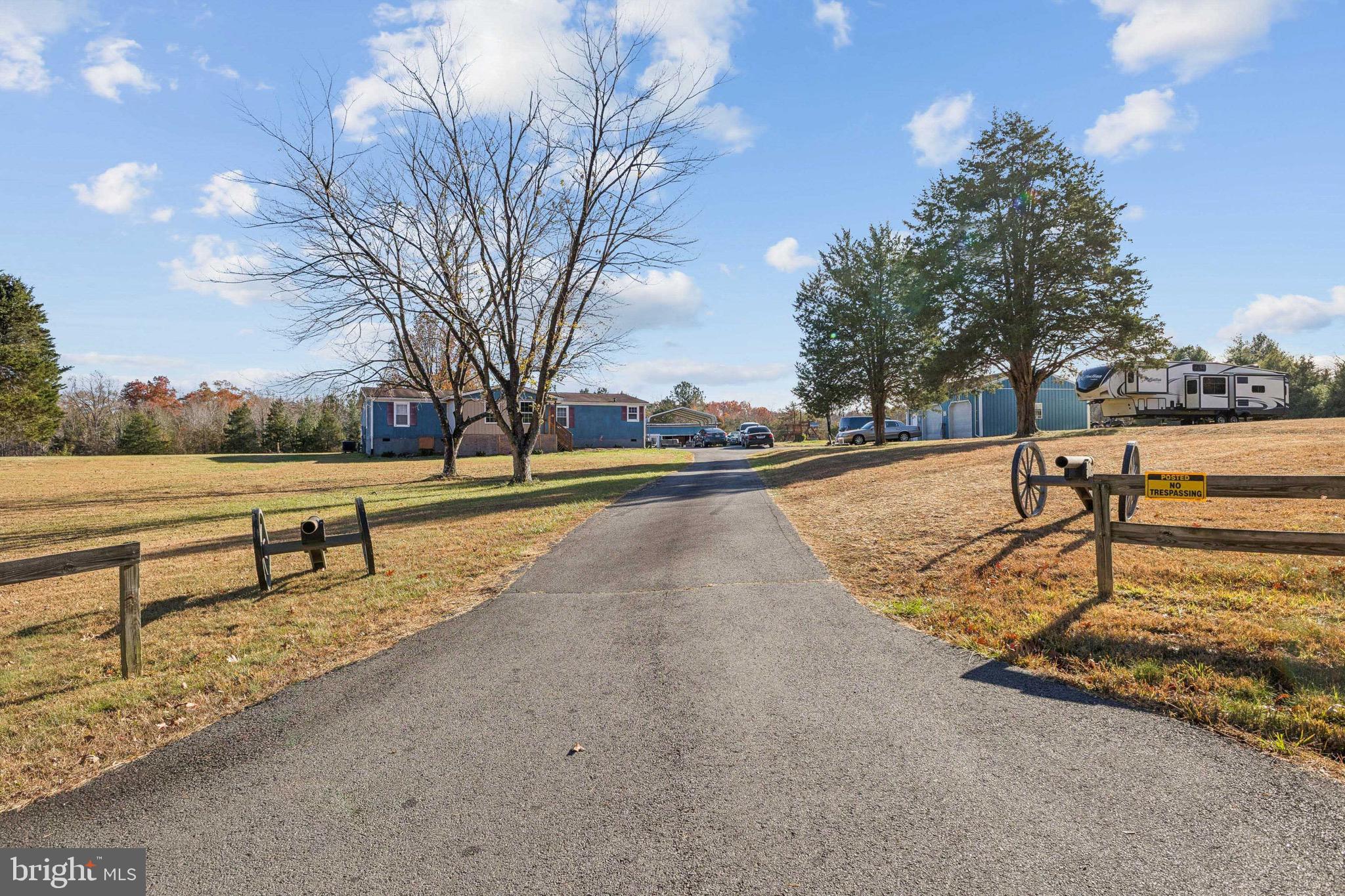 a view of street with yard and trees in the background